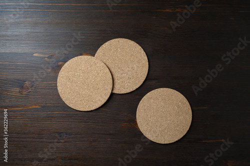 Blank cork beer coasters on wooden background. Responsive design template. Top view. Flat lay.