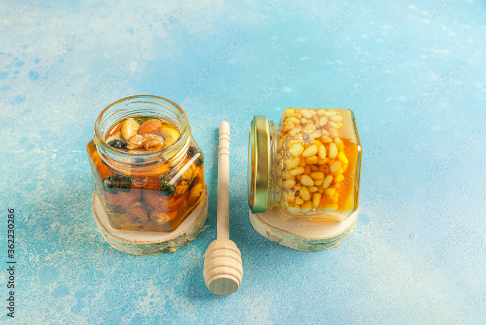 Jar of honey and nuts with a honey spoon Jar of honey and nuts with a honey spoon