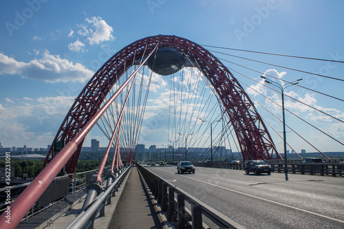 View of the picturesque red bridge serez Moscow river and modern architectural structures on a clear summer day © Inna