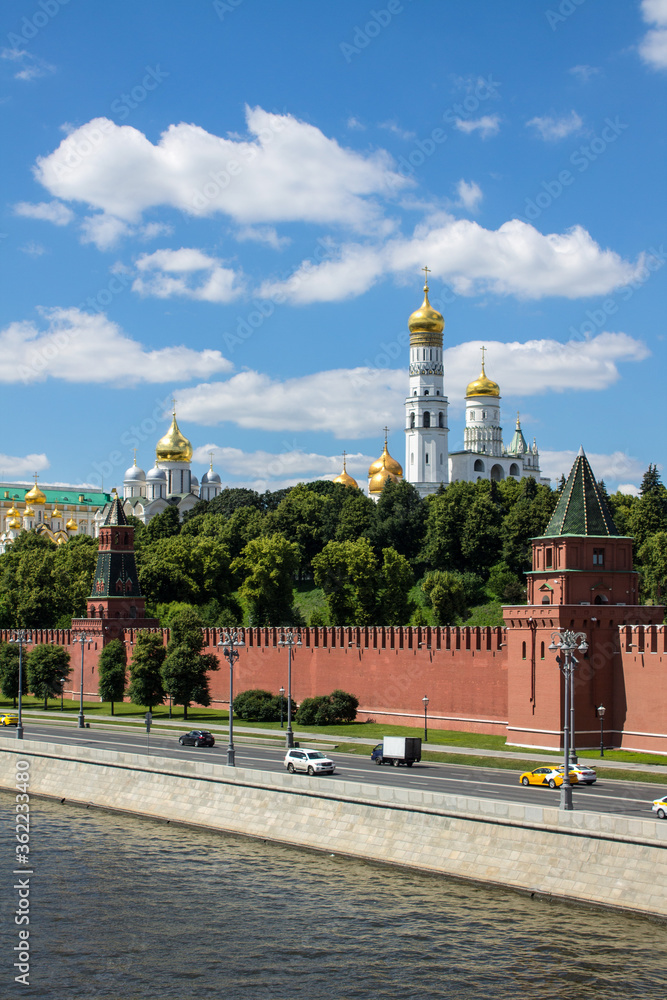 Panoramic view of the historical center of Moscow Russia with the red brick Kremlin wall and the assumption Cathedral with Golden domes against a bright blue sky and space for copying