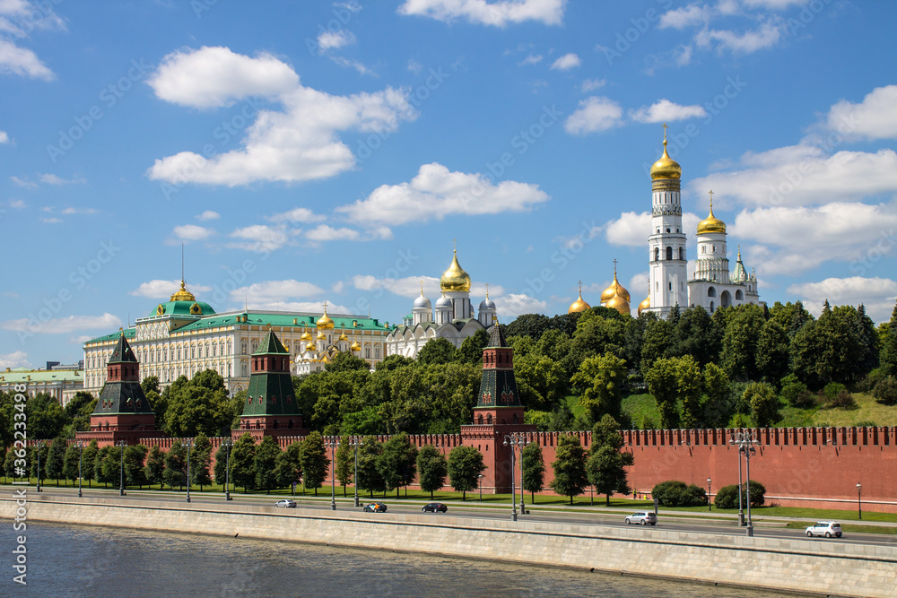 Obraz premium Panoramic view of the historical center of Moscow Russia with the red brick Kremlin wall and the assumption Cathedral with Golden domes against a bright blue sky and space for copying