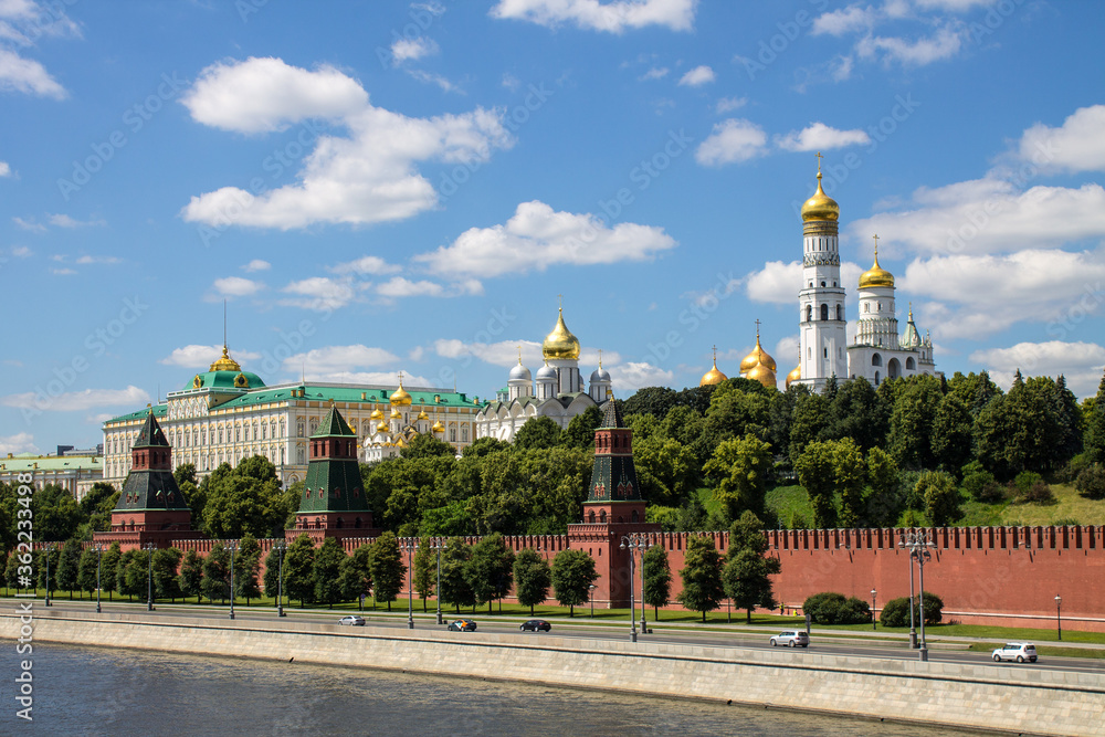 Panoramic view of the historical center of Moscow Russia with the red brick Kremlin wall and the assumption Cathedral with Golden domes against a bright blue sky and space for copying