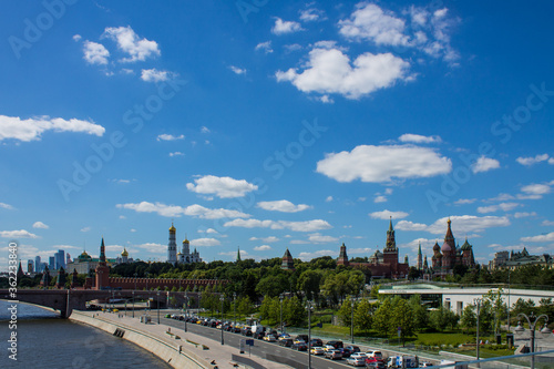 panoramic view of the brick wall and the Kremlin towers and skyscrapers of Moscow city in the background on the blue sky and the Moscow river on a clear summer day