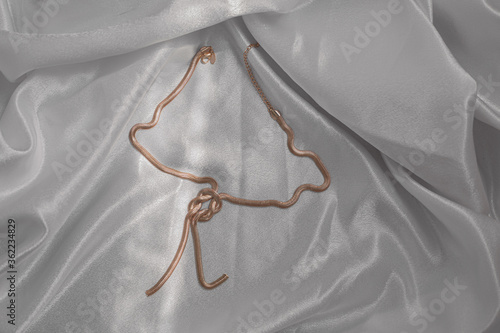 Women's gold necklace on a grey fabric
