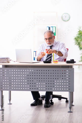 Old sick employee suffering at workplace