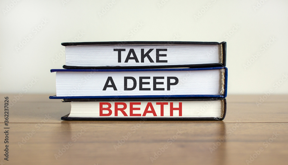 Books with text 'take a deep breath' on beautiful wooden table. White background. Business concept.