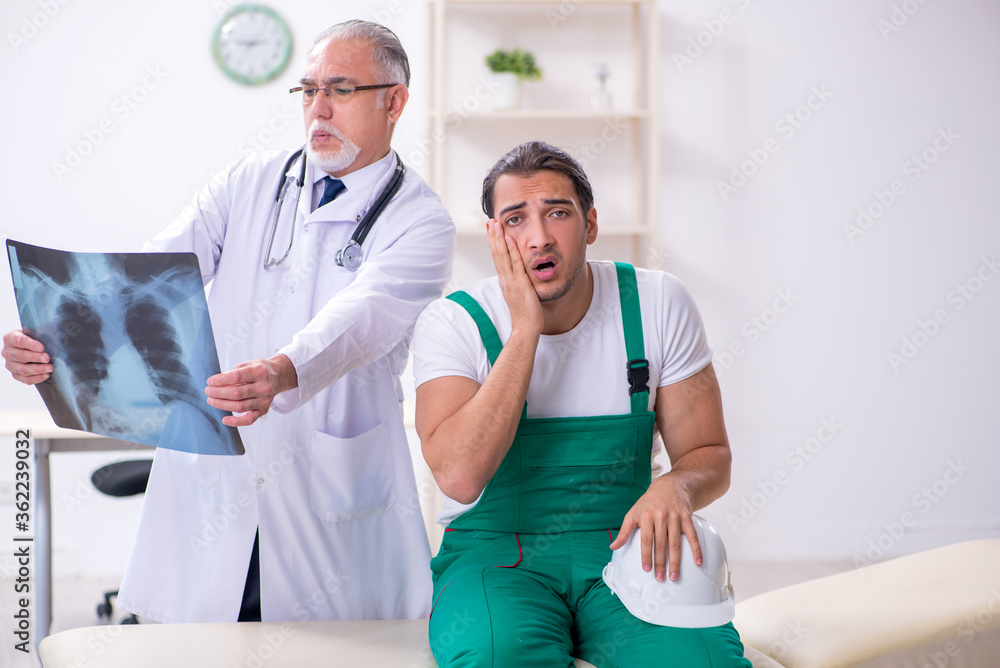 Obraz premium Young male contractor visiting old doctor