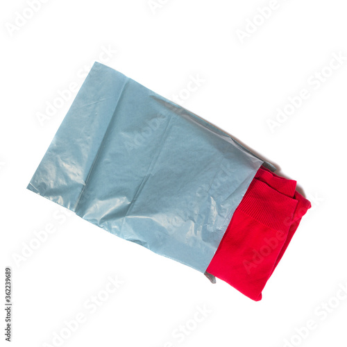red jumper packed in gray mailing bag on white background