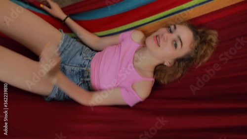 Coquette young woman fool around lying and relaxing on hammock