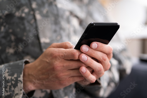 фотографія Social Cyber Warfare. Army Soldier Using Phone