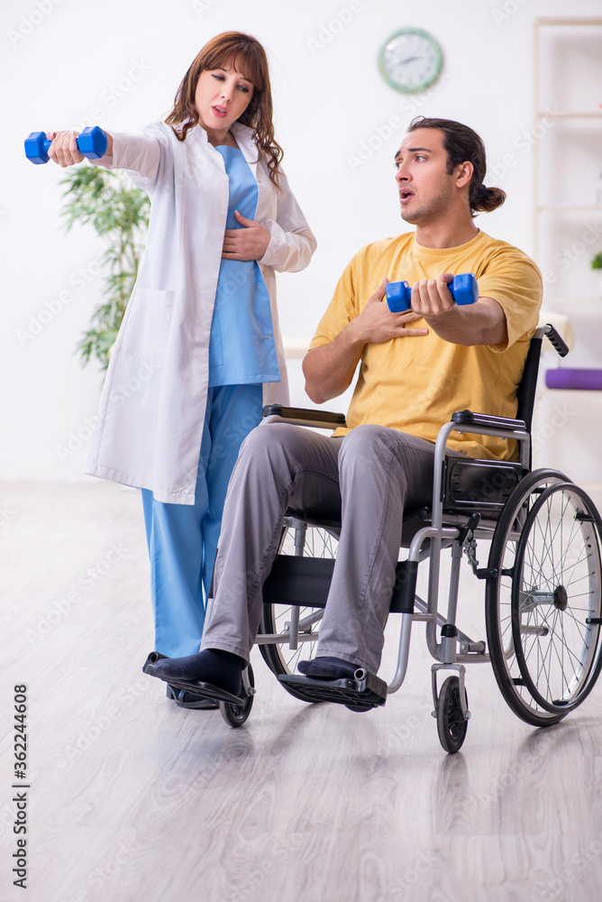 Young male patient in wheel-chair doing physical exercises Young male patient in wheel-chair doing physical exercises