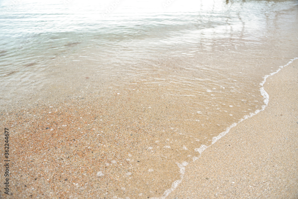 calm sea, small waves, clear and transparent water, small sand near the shore
