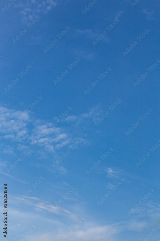 The sky on a sunny day with clouds floating in a lump for a clear feeling. Use as a vertical background that feels clear and relaxed. 