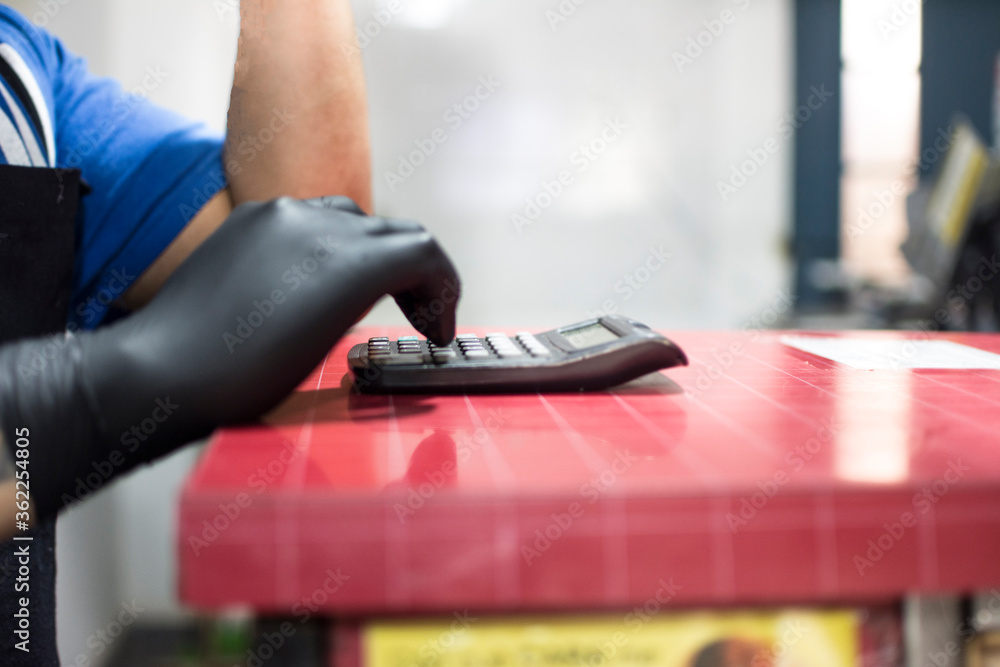 Fototapeta premium Worker using a calculator on a counter