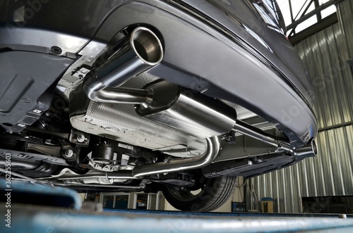 New generation of sportive mufflers. Oval or round Car Exhaust Tailpipe chromed made of stainless steel on powerful sport car bumper. Close up photo