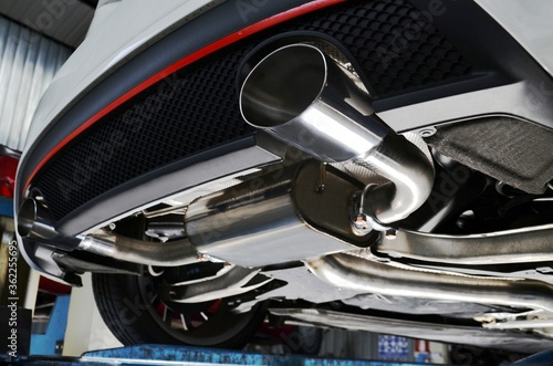 New generation of sportive mufflers. Oval or round Car Exhaust Tailpipe chromed made of stainless steel on powerful sport car bumper. Close up photo