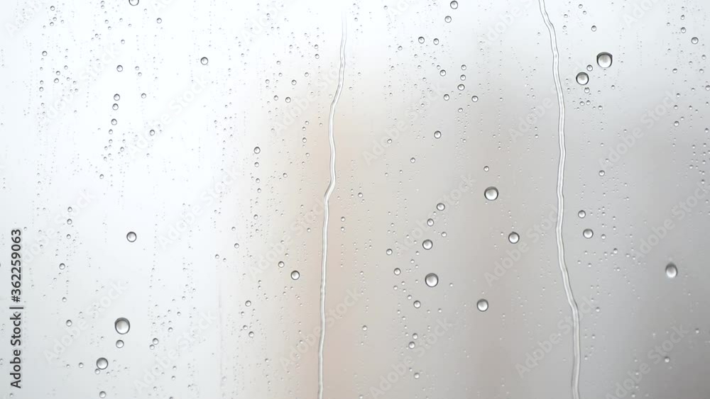 Macro photography of raindrops streaming down on the window. Rain outside the window Macro photography of raindrops streaming down on the window. Rain outside the window