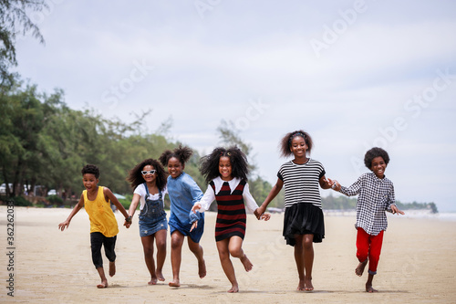 Funny vacation. Children or kids playing and romp together at the beach on holiday. Having fun after unlocking down the city from COVID19. Seven African American kids. Ethnically diverse concept.