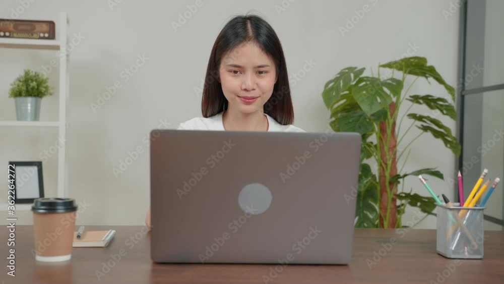 Young Asian woman using laptop with working on desk at home office. Young Asian woman using laptop with working on desk at home office.