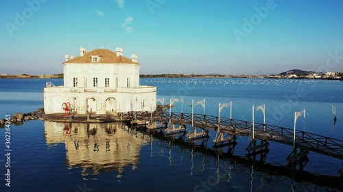 Casina Vanvitelliana and Fusaro lake, little house located in Italy, wooden bridge and small island of Bacoli, the building is reflected in the water photo