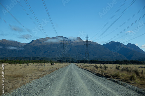 Gravel road going into mountains underneath power lines