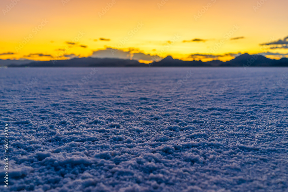 Obraz premium Bonneville Salt Flats colorful purple dark twilight mountains silhouette open low angle ground level view after sunset near Salt Lake City, Utah with clouds