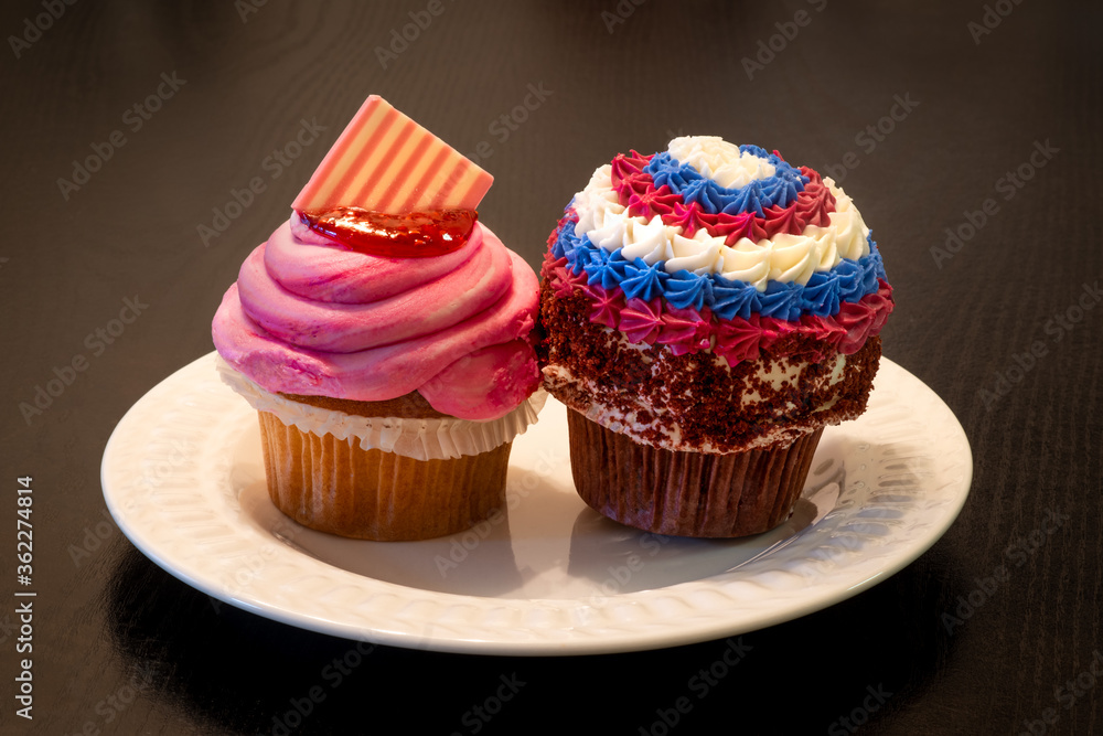Patriotic homemade raspberry and vanilla and chocolate cupcakes with American colors, red, white, and blue icing, for Fourth of July (American Independence Day).