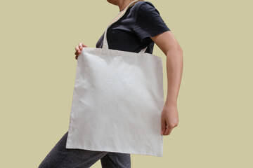 Woman holding reusable white cotton linen eco organic fabric tote bag isolated blank background for mockup with clipping path
