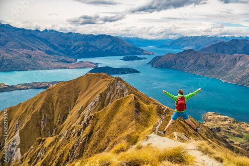 Hiker jumping of joy funny - man hiking in New Zealand. Roys Peak, South Island, New Zealand.