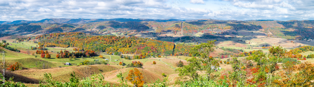 Colorful fall maple trees and farm house land rolling hills aerial above high angle view landscape panorama in Blue Grass, Highland County, Virginia Colorful fall maple trees and farm house land rolling hills aerial above high angle view landscape panorama in Blue Grass, Highland County, Virginia