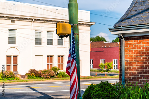 Orange, Virginia historic downtown town city in countryside with brick buildings on street and american flag at pedestrian crossing light