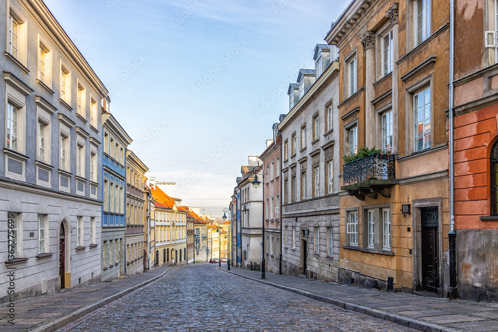 Warsaw, Poland old town historic cobblestone road street empty narrow alley during sunny sunset sunrise winter day morning