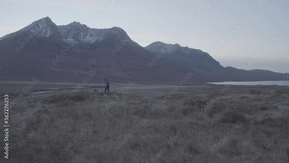 Man taking photographs of the sunset over the North West Scottish highland mountains. Beinn Dearg Mor and Beinn Dearg Man taking photographs of the sunset over the North West Scottish highland mountains. Beinn Dearg Mor and Beinn Dearg
