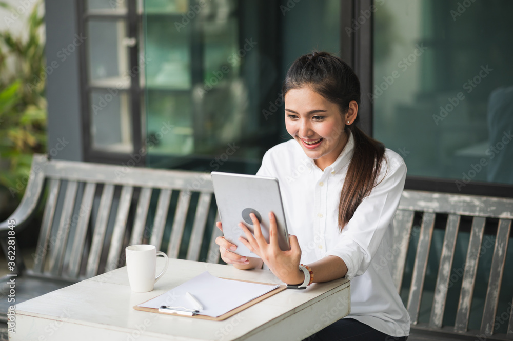 Beautiful asian women conferencing work from home with tablet. Smiling charming happy young female stay at home. Beautiful asian women conferencing work from home with tablet. Smiling charming happy young female stay at home.