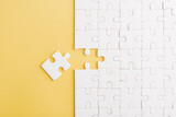 Top view flat lay of paper plain white jigsaw puzzle game texture last pieces for solve and place, studio shot on a yellow background, quiz calculation concept