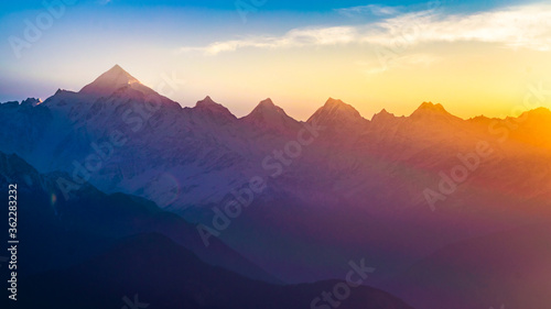 Mountain silhouette of Panchchuli peaks during morning sunrise in great Himalayan mountain chain range from Khalia Top at small hamlet Munsiyari, Kumaon region, Uttarakhand, India.