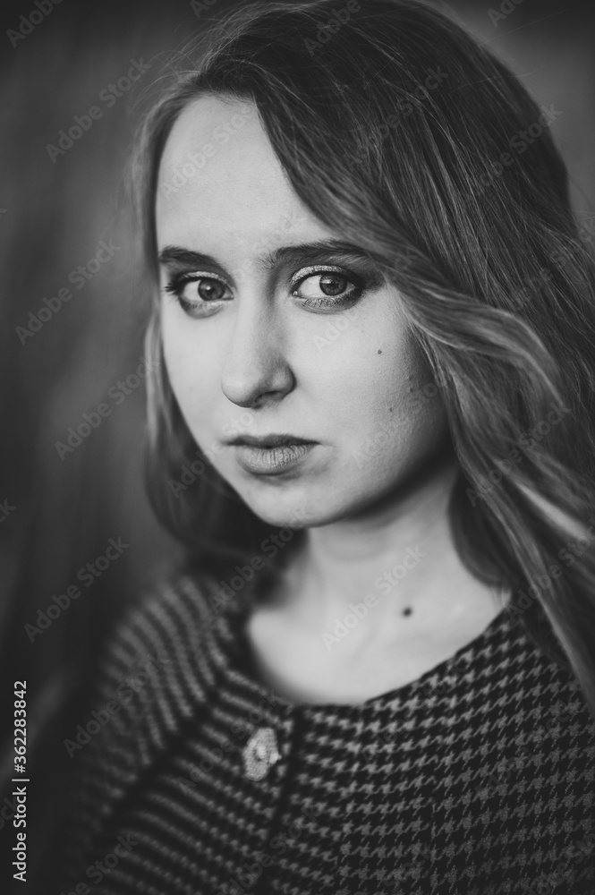 Portrait of a beautiful girl in autumn on the background the nature. upper half length. Close up. looking at the camera. Black and white photo.