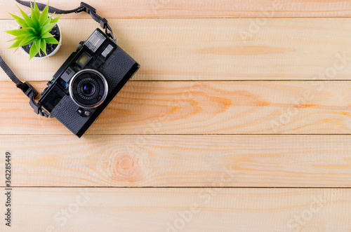 Vintage camera on wooden table background with copy space. World photography day conept.