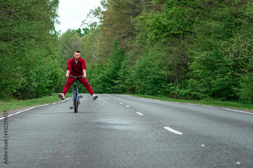 Wallpaper Mural Happy male riding bike with legs up. The road in the forest. The concept of a healthy lifestyle, cardio training. Copyspace. Torontodigital.ca