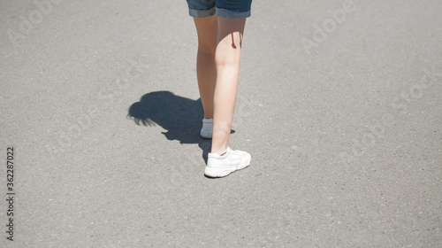 Woman with white sneaker walking outdoor.