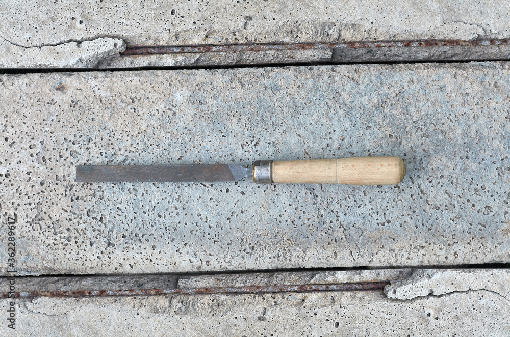 metal hand file with old wooden handle on concrete background metal hand file with old wooden handle on concrete background