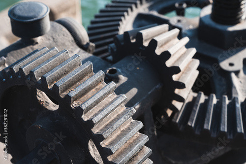 Fotografie Old black mechanical cog on a flood gate