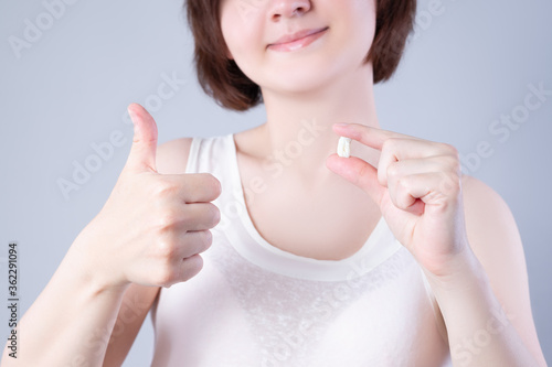Photography Wisdom teeth extraction, happy woman with tooth in hand on gray background