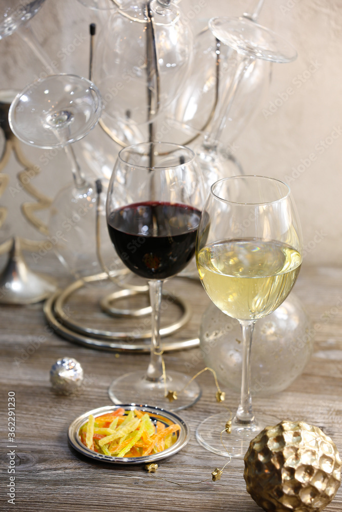 Glasses with red and white wine and snacks on a gray background