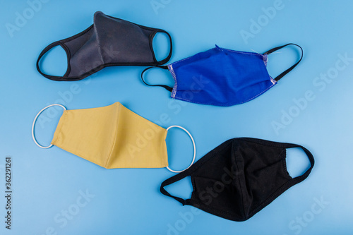 Set of reusable fabric masks on blue background. Top view. Concept of coronavirus prevention