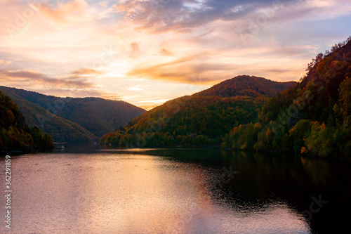 sunset on the tarnita lake in romania. beautiful nature scenery in autumn at dusk. gorgeous sky with glowing clouds