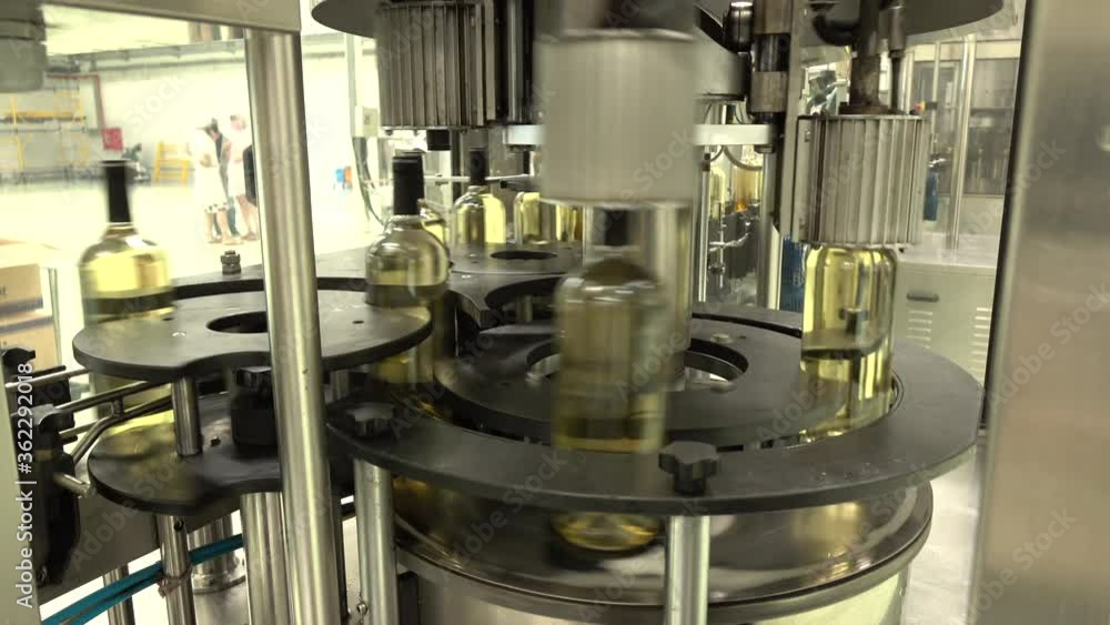 Wine production factory. Glass bottles filled up with white wine Wine production factory. Glass bottles filled up with white wine