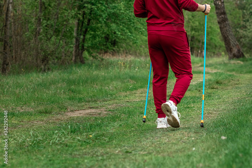 Nordic walking, sticks, legs close-up. The concept of a healthy lifestyle, cardio training. Copyspace.