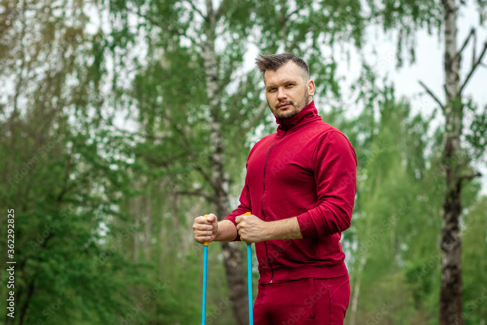 Fototapeta premium Nordic walking, sticks, hands close-up. The concept of a healthy lifestyle, cardio training. Copyspace.