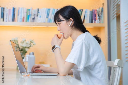 In the study, a pure girl is using a computer

